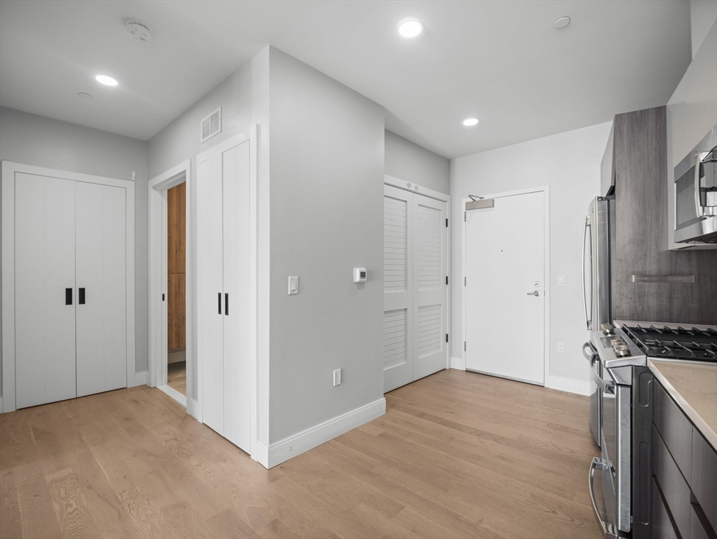 9 Central Street, Unit 207 Somerville, MA 02143 - Photo 3 of 32 a view of empty room with wooden floor and electronic appliances
