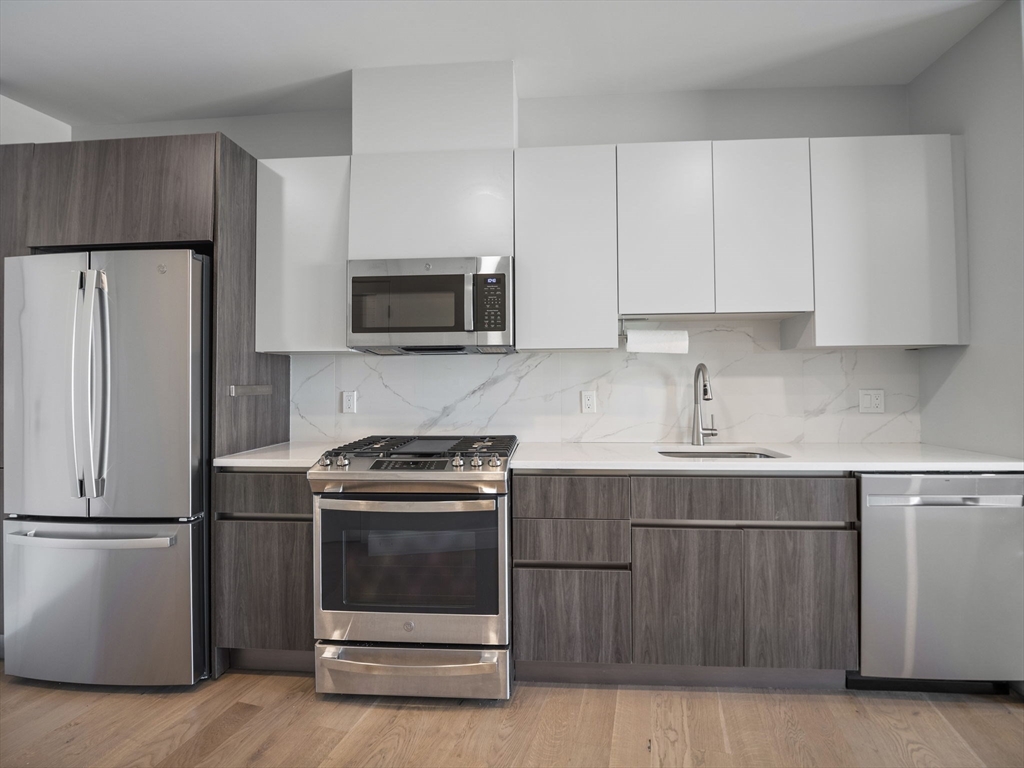 9 Central Street, Unit 207 Somerville, MA 02143 - Photo 6 of 32 a kitchen with a sink stove and refrigerator