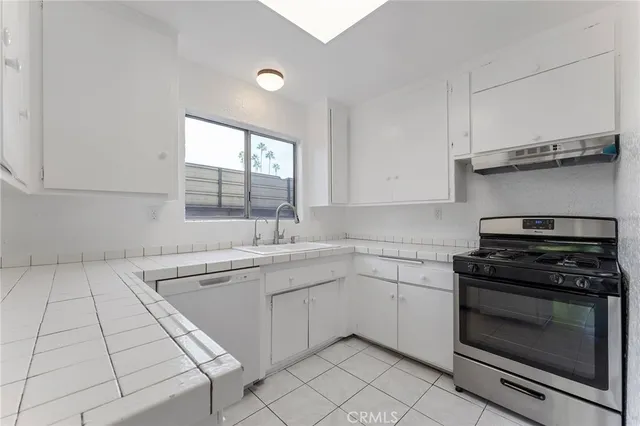 a kitchen with cabinets appliances and a window