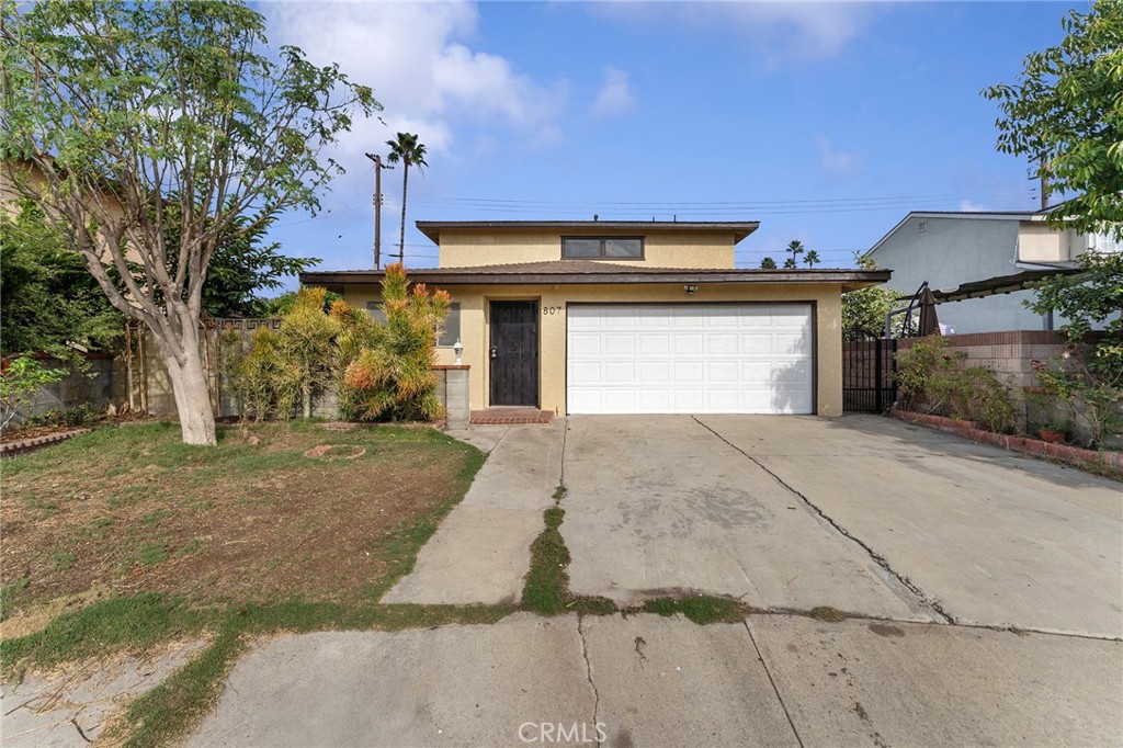 807 East Calbas Street Carson, CA 90745 - Photo 2 of 31 a front view of a house with a yard and garage