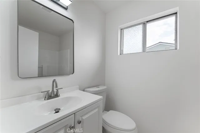 a bathroom with a sink vanity mirror and toilet