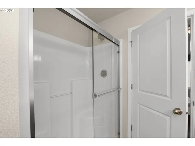a bathroom with a shower and a glass door