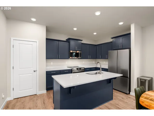 a kitchen with a sink refrigerator and cabinets