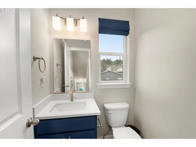 a bathroom with a sink toilet a mirror and window