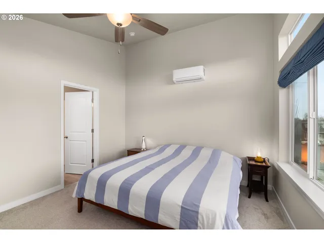 a bedroom with a bed and a large window