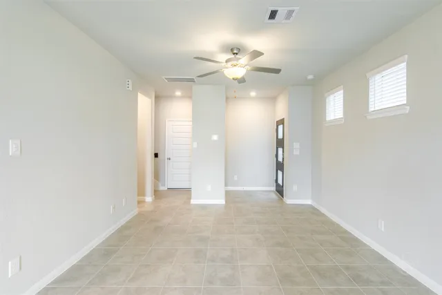 a view of a big room with chandelier fan and windows