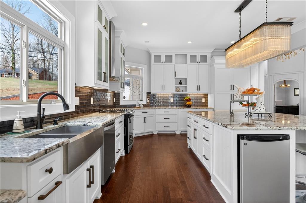 3944 Hamilton Mill Road Buford, GA 30519 - Photo 15 of 55 a kitchen with stainless steel appliances granite countertop a sink a stove and a wooden floors