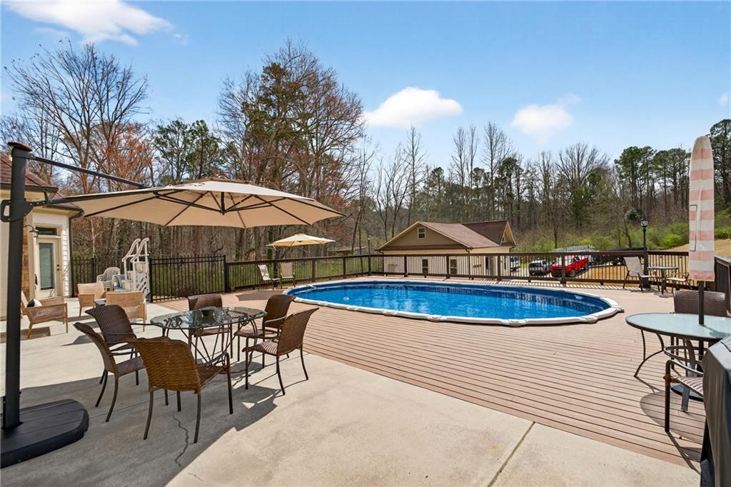 3944 Hamilton Mill Road Buford, GA 30519 - Photo 23 of 55 a view of a swimming pool with lawn chairs under an umbrella