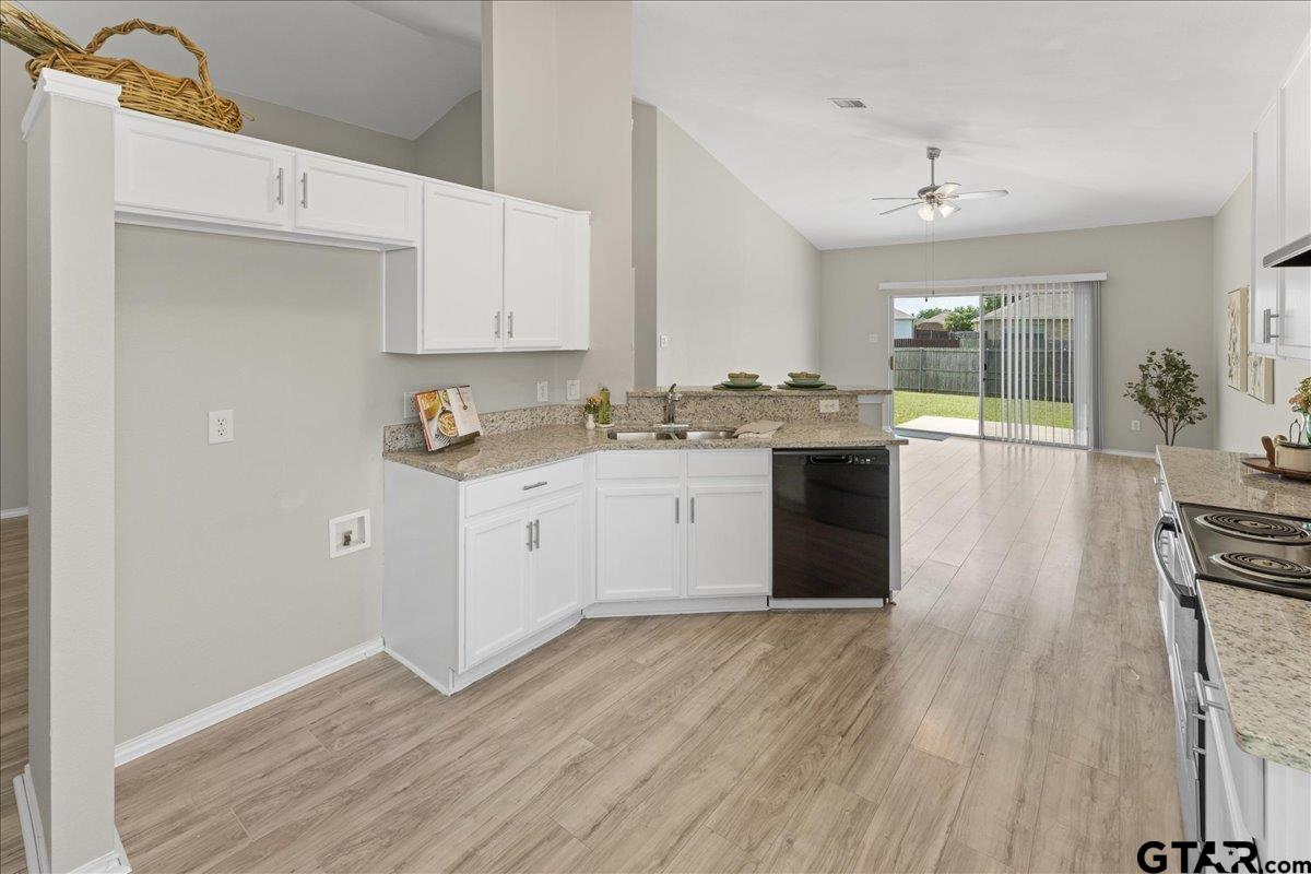 205 Freedom Trail Forney, TX 75126 - Photo 15 of 41 a white kitchen with wooden floor and stainless steel appliances
