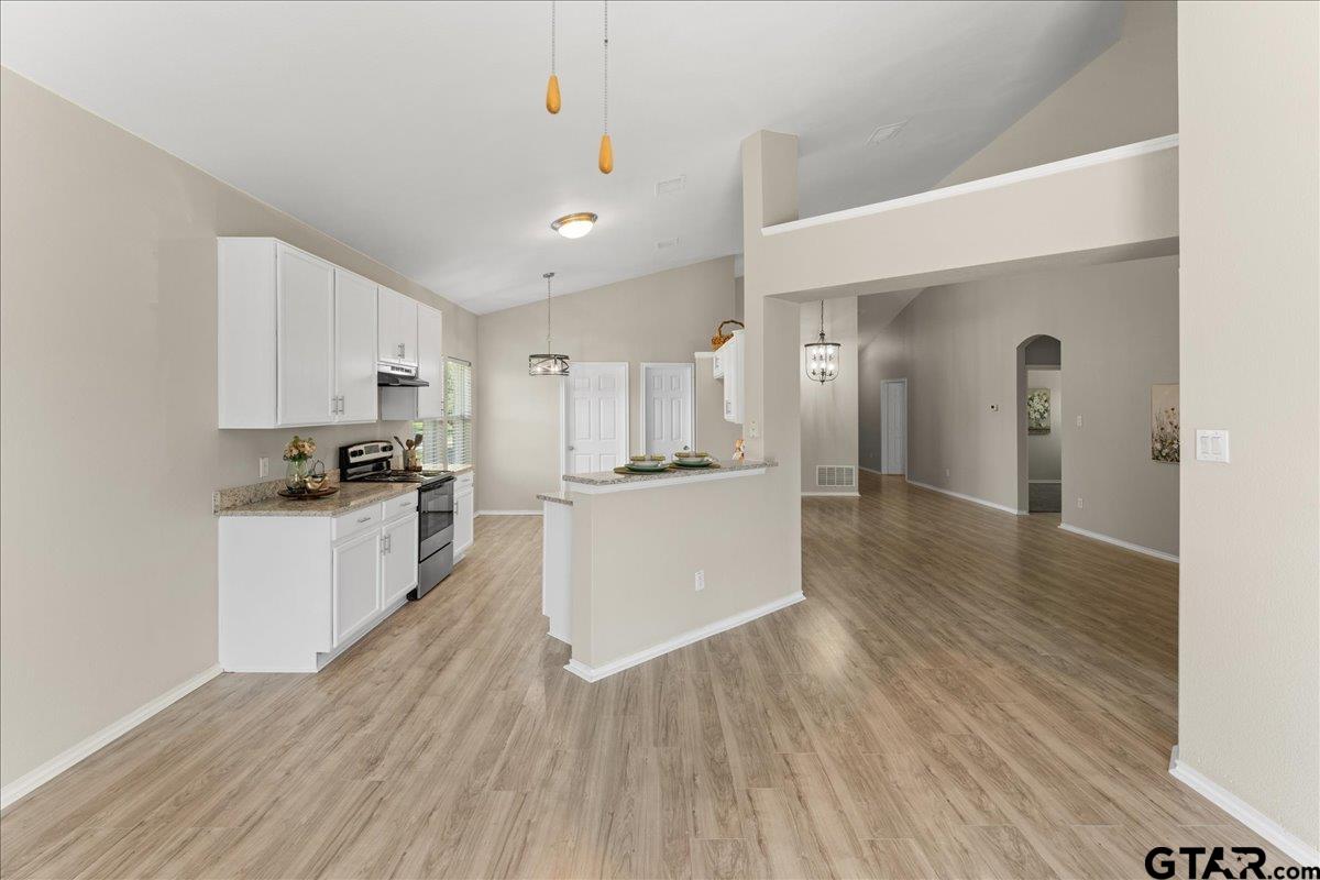 205 Freedom Trail Forney, TX 75126 - Photo 17 of 41 a kitchen with wooden floors and white cabinets