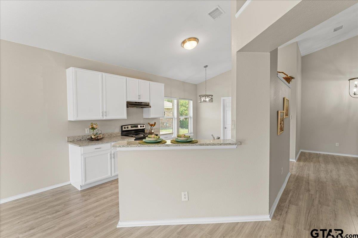 205 Freedom Trail Forney, TX 75126 - Photo 18 of 41 a kitchen with stainless steel appliances granite countertop a refrigerator a stove a sink and white cabinets with wooden floor