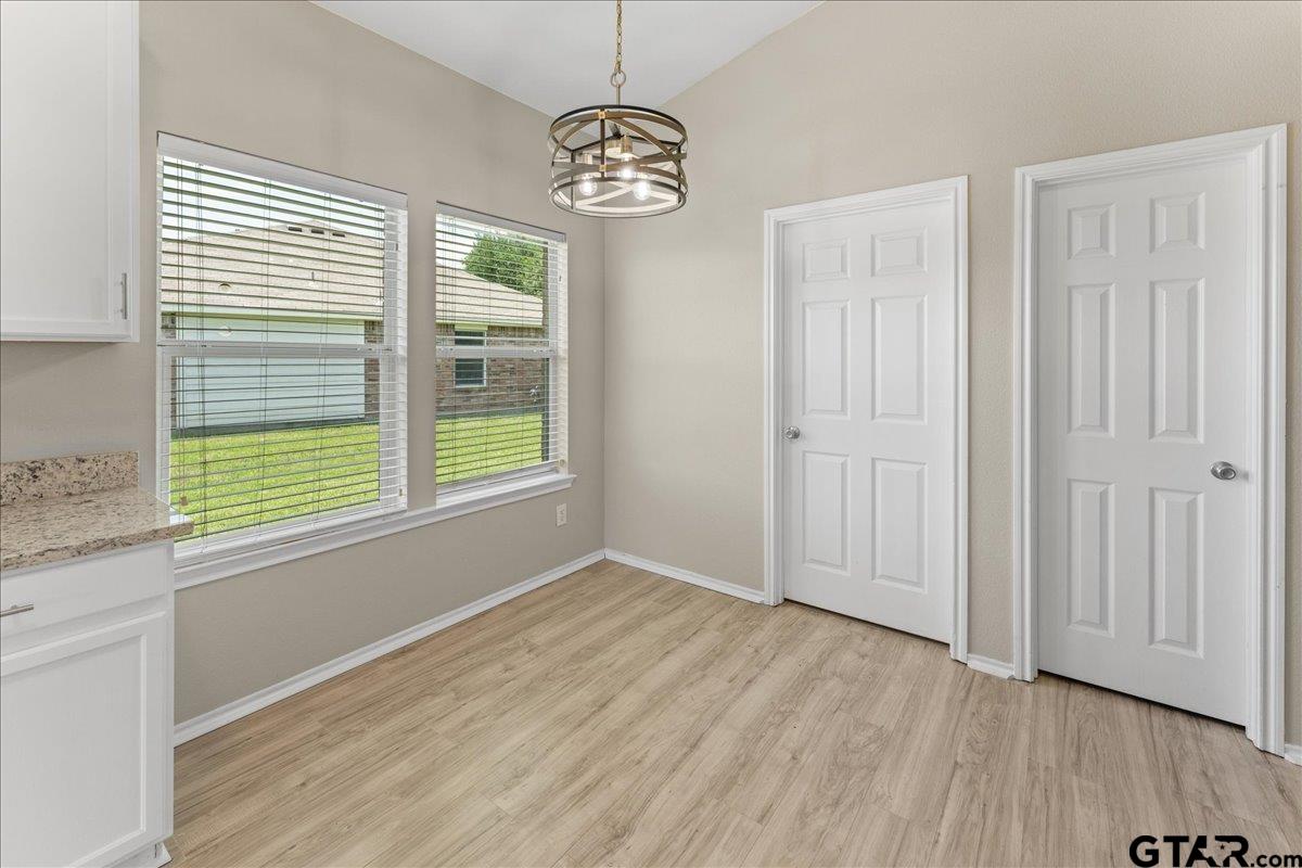 205 Freedom Trail Forney, TX 75126 - Photo 21 of 41 a view of an empty room with window wooden floor and a kitchen