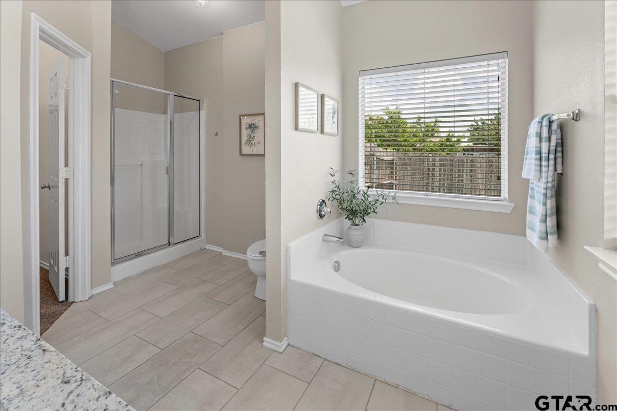 205 Freedom Trail Forney, TX 75126 - Photo 27 of 41 a white bath tub sitting in a spacious bathroom next to a window