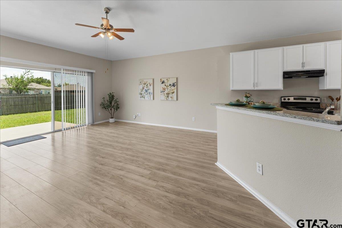 205 Freedom Trail Forney, TX 75126 - Photo 9 of 41 a kitchen with granite countertop a stove a sink and wooden floors