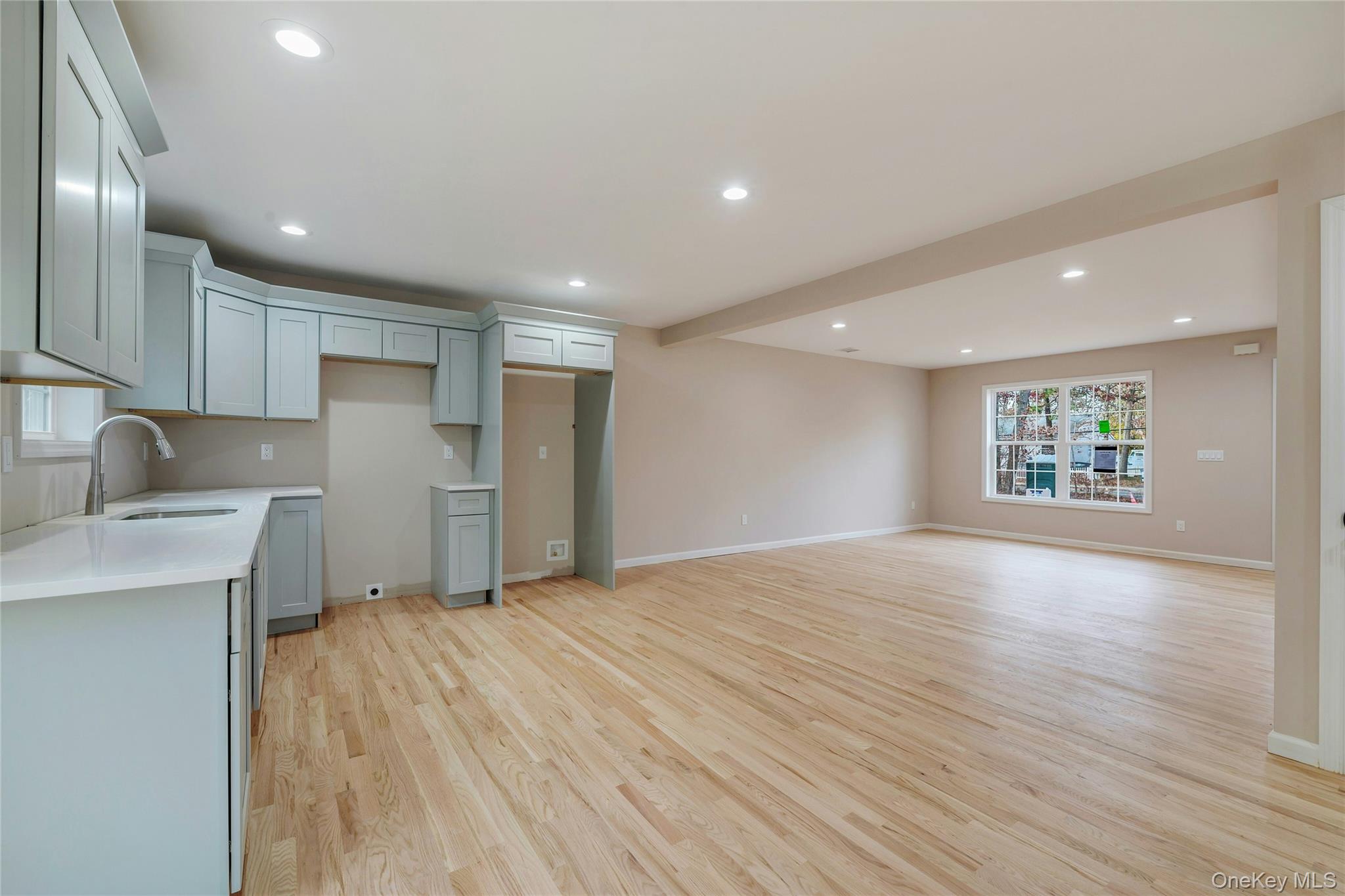 487 Neighborhood Road Shirley, NY 11967 - Photo 19 of 20 a view of an empty room with a window and wooden floor