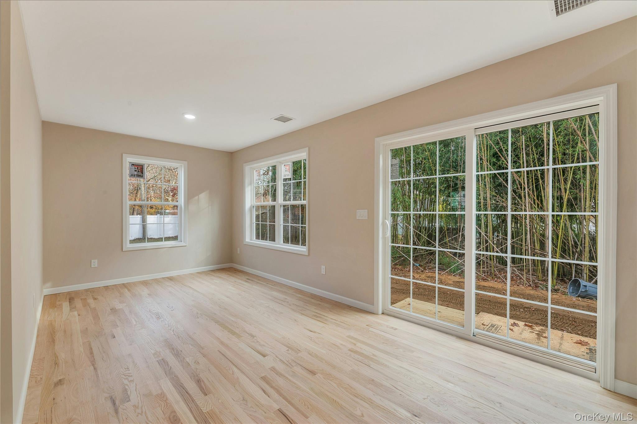 487 Neighborhood Road Shirley, NY 11967 - Photo 6 of 20 a view of empty room with wooden floor and windows
