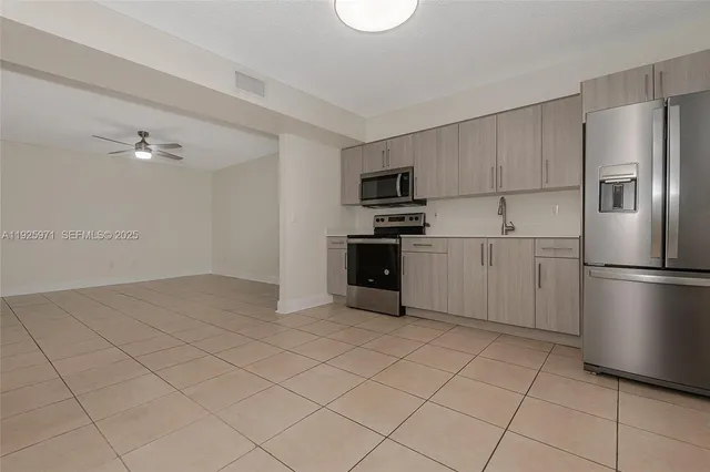 a kitchen with stainless steel appliances granite countertop a refrigerator sink and stove