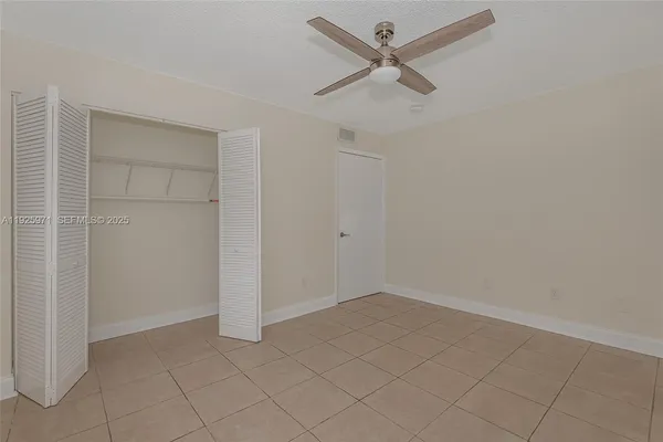 an empty room with closet and fan