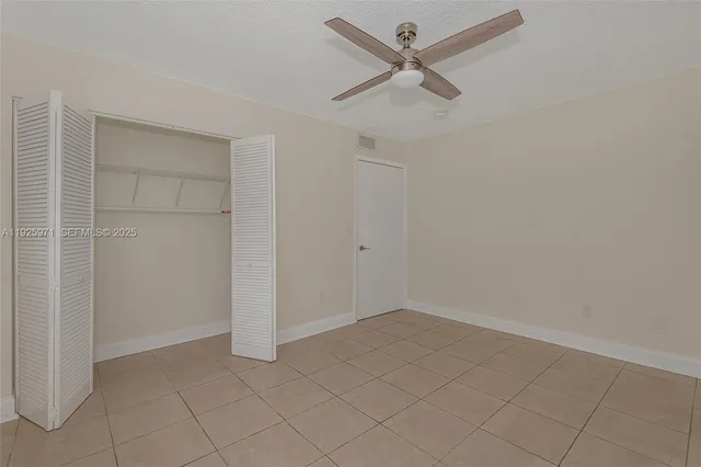 an empty room with closet and fan