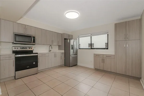 a kitchen with a refrigerator sink and cabinets