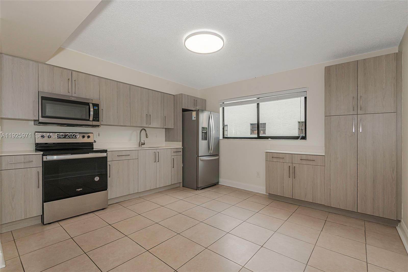 Hialeah Hialeah, FL 33012 - Photo 8 of 27 a kitchen with a refrigerator sink and cabinets
