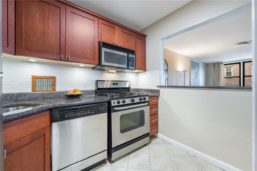 515 East 7th Street, Unit 3P Brooklyn, NY 11218 - Photo 9 of 14 a kitchen with stainless steel appliances granite countertop a stove microwave and sink