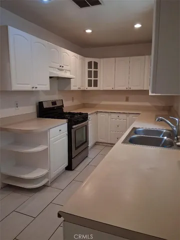 a kitchen with a sink a stove and cabinets