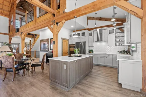a kitchen that has a lot of white cabinets and stainless steel appliances