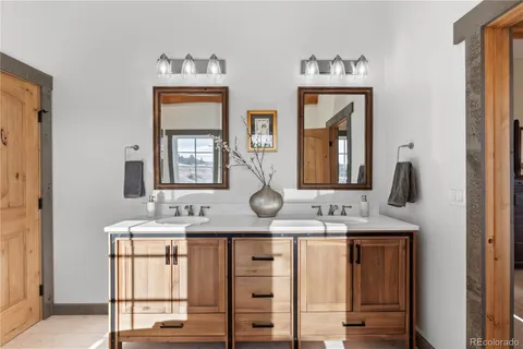 a bathroom with double vanity sinks and a mirror