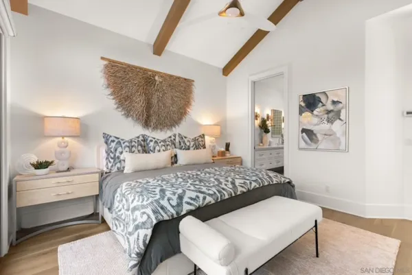 a bedroom with a bed and a painting on the wall