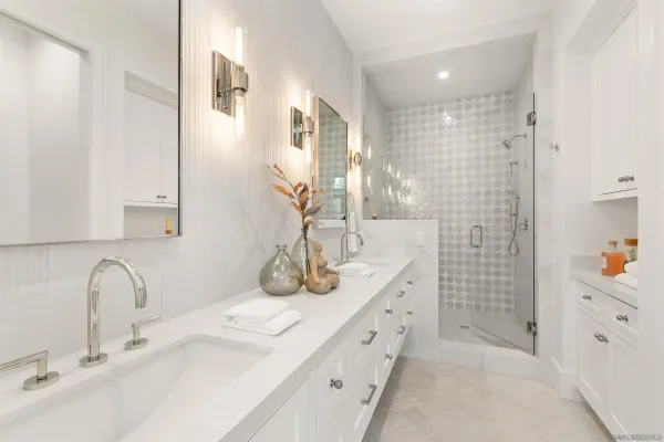 a bathroom with a double vanity sink mirror and shower