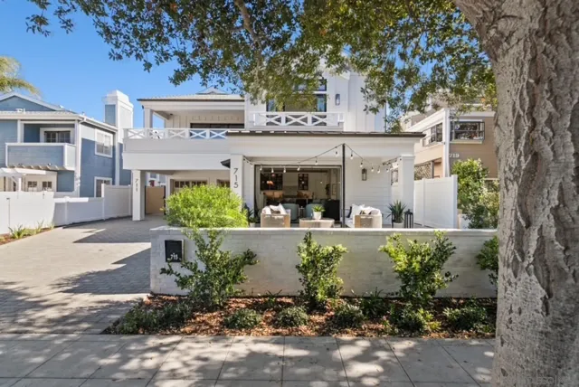 a view of a house with potted plants and large tree