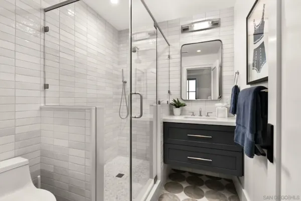 a bathroom with a sink a toilet and shower