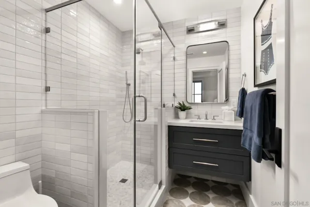 a bathroom with a sink a toilet and shower