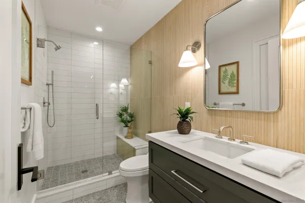 a bathroom with a granite countertop sink toilet and shower