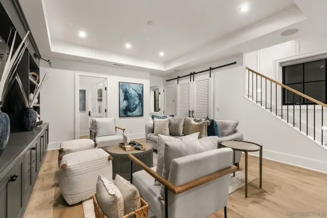 a living room with furniture a flat screen tv and a window