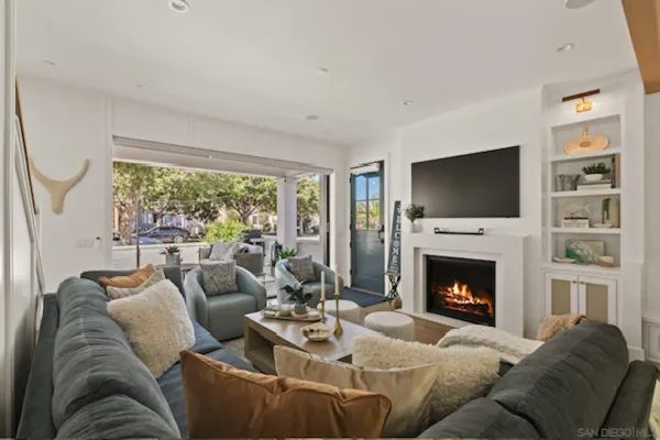 a living room with furniture a flat screen tv and a fireplace