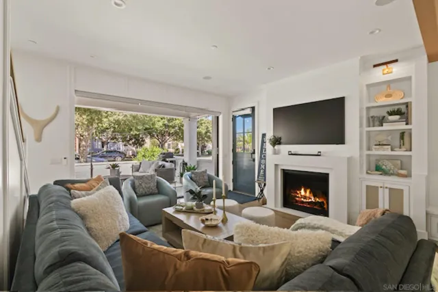 a living room with furniture a flat screen tv and a fireplace