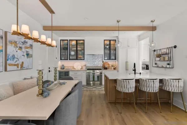 a living room with furniture a chandelier and a dining table