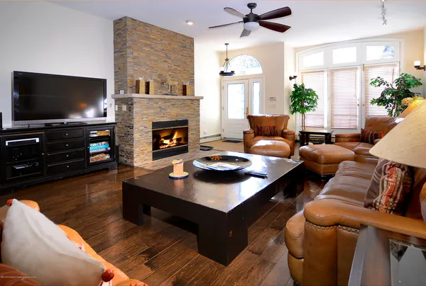 a living room with furniture a flat screen tv and a fireplace
