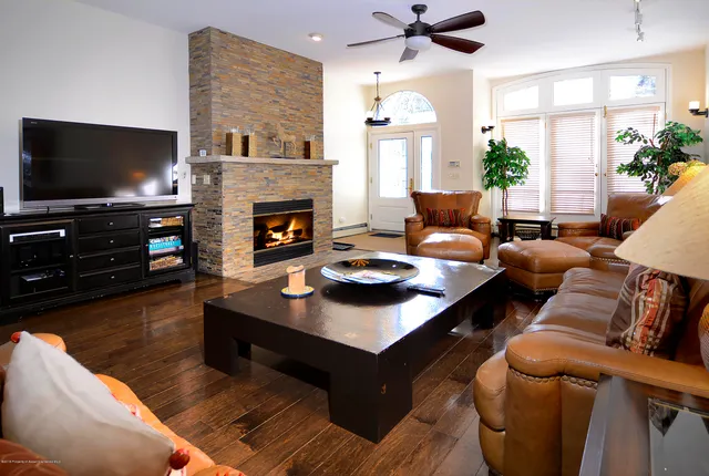 a living room with furniture a flat screen tv and a fireplace