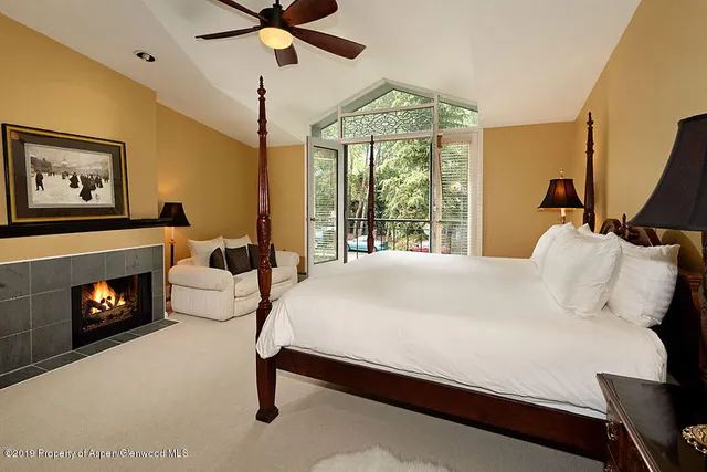 a bedroom with a bed and a fireplace