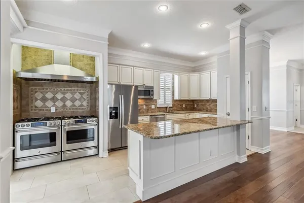 a kitchen with stainless steel appliances granite countertop a stove and a refrigerator