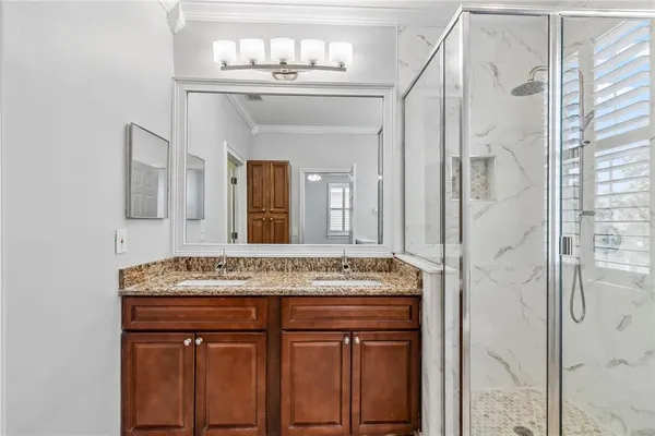 a bathroom with a granite countertop sink a mirror and a shower