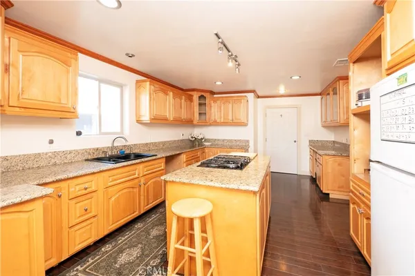 a kitchen with granite countertop a sink stove and refrigerator