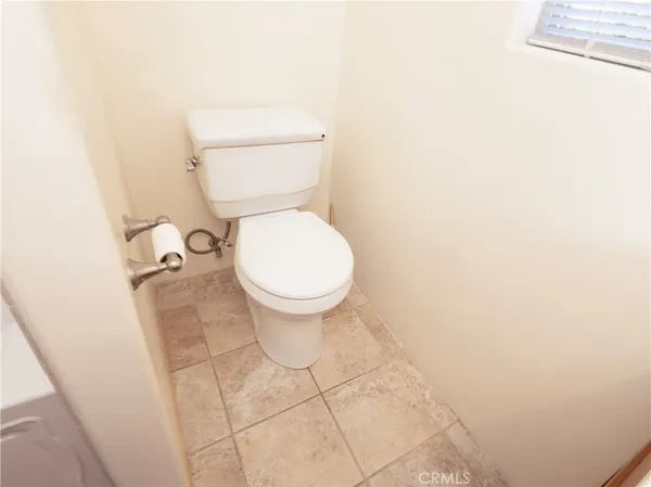 a white toilet sitting next to a white wall