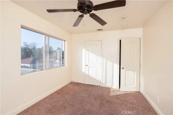 a view of a livingroom with a ceiling fan and window