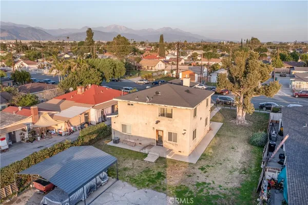 an aerial view of residential houses with outdoor space and trees