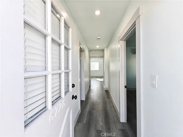 a view of a hallway with wooden floor and entryway