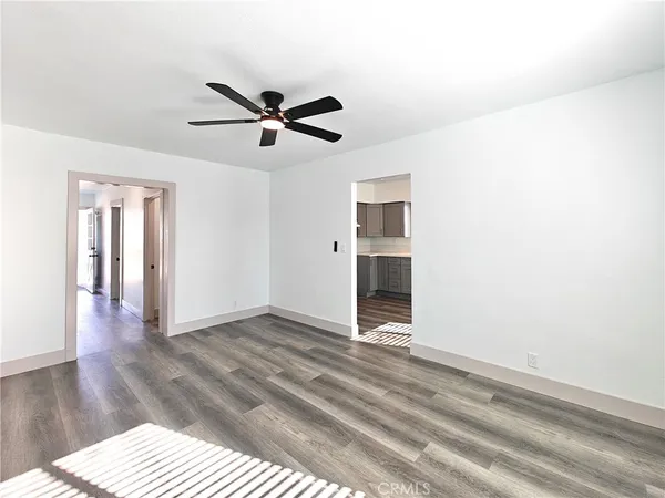 a view of a livingroom with wooden floor and a ceiling fan